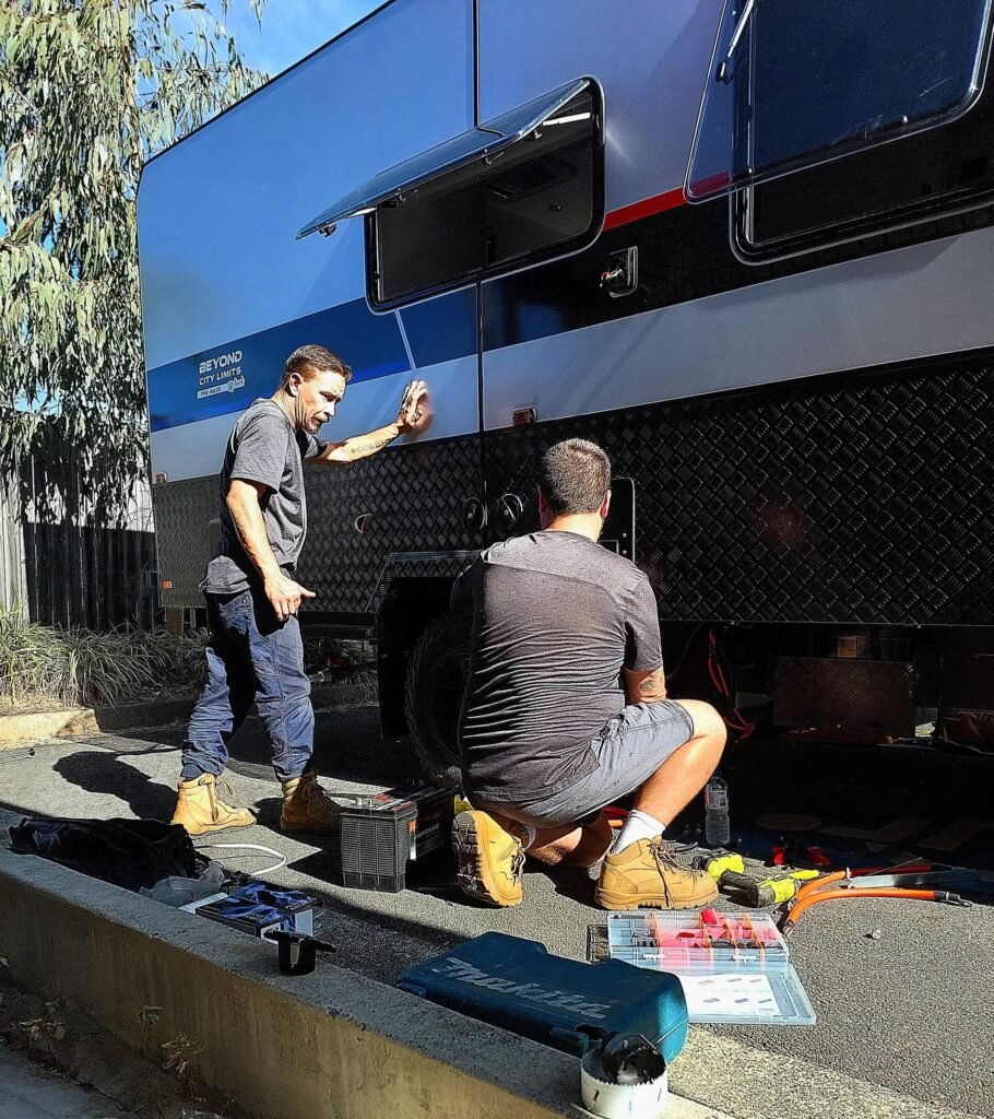 Two Queensland Mobile Caravan Services technicians working on a caravan on site